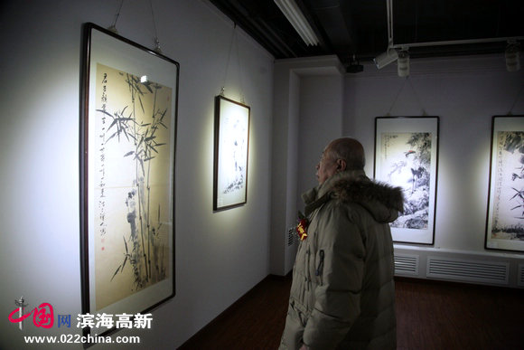 画家王俊生在观看画展。