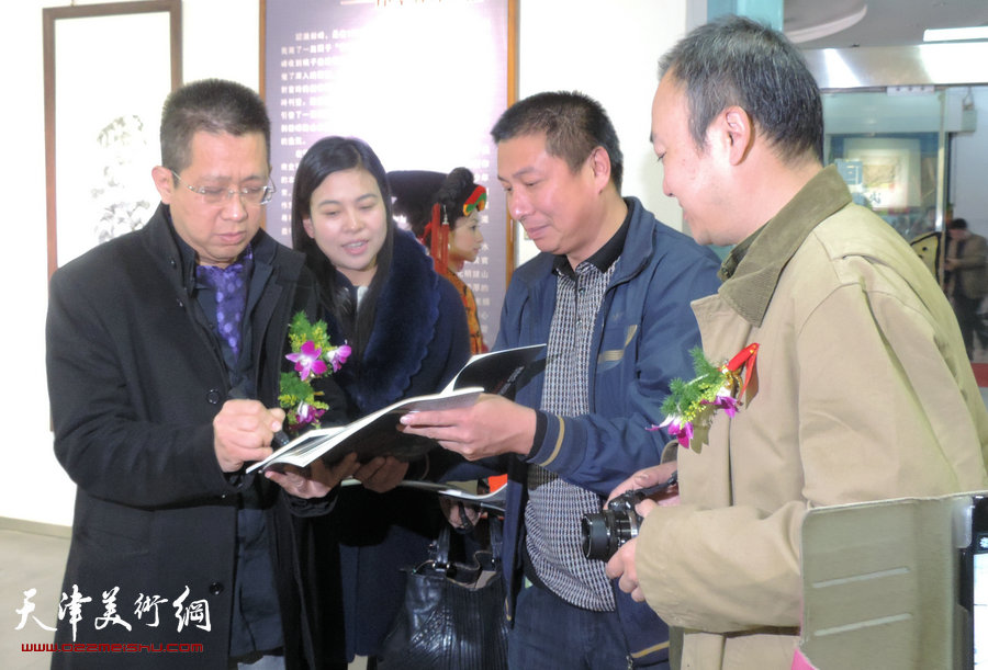 “谦谦峰骨 李毅峰中国画巡回展”青州站开幕，图为李毅峰在展览现场为观众签名。