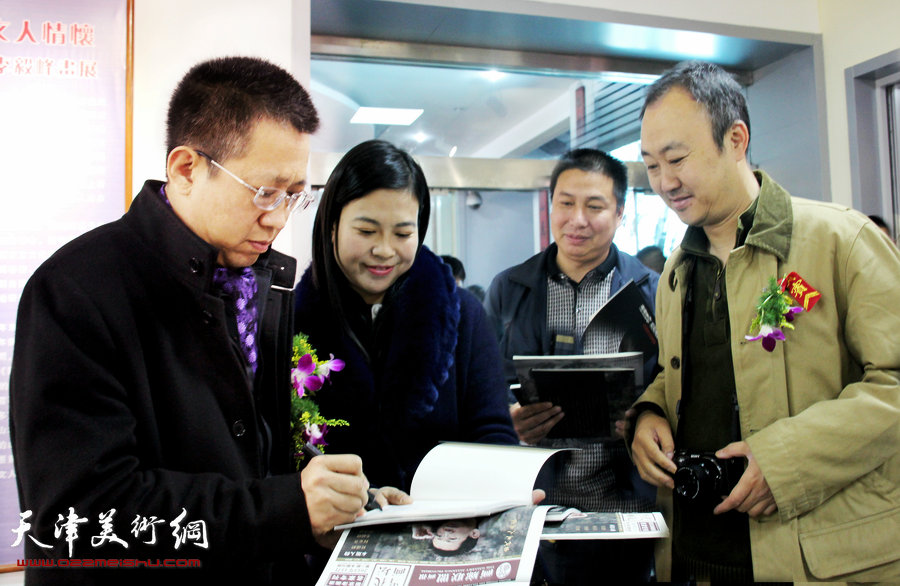 “谦谦峰骨 李毅峰中国画巡回展”青州站开幕，图为李毅峰在展览现场为观众签名。