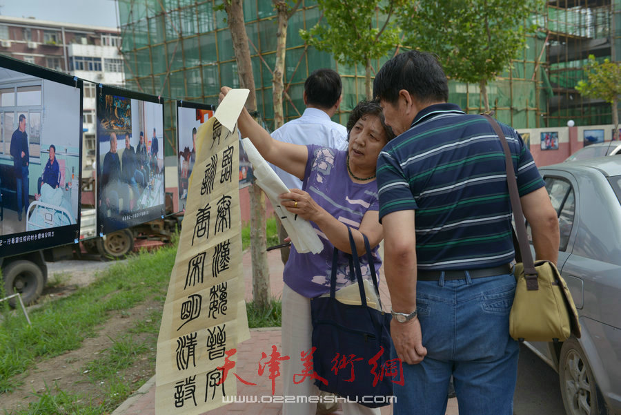 第四届“天穆杯”书画摄影展在北辰区天穆东苑举行，图为天穆村民参观作品。