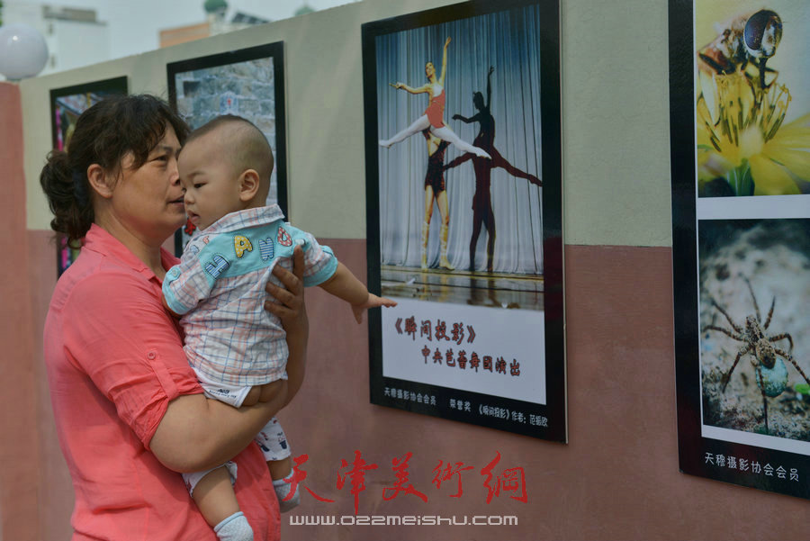 第四届“天穆杯”书画摄影展在北辰区天穆东苑举行，图为天穆村民参观作品。