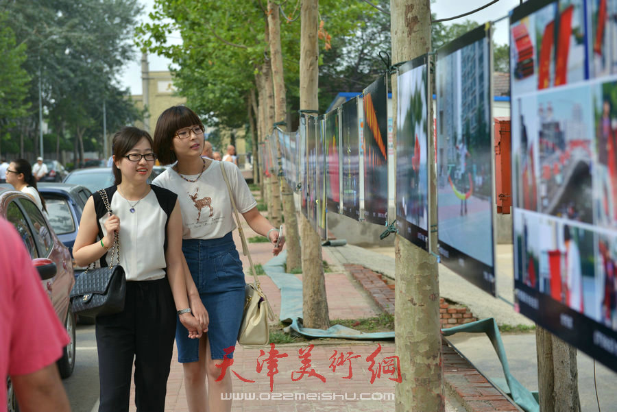 第四届“天穆杯”书画摄影展在北辰区天穆东苑举行，图为观众参观作品。