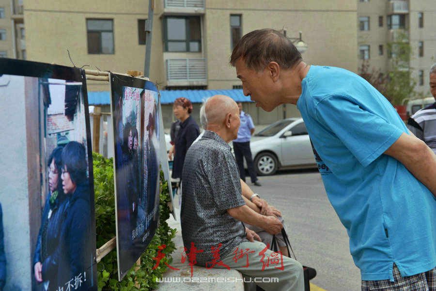 第四届“天穆杯”书画摄影展在北辰区天穆东苑举行，图为观众参观作品。