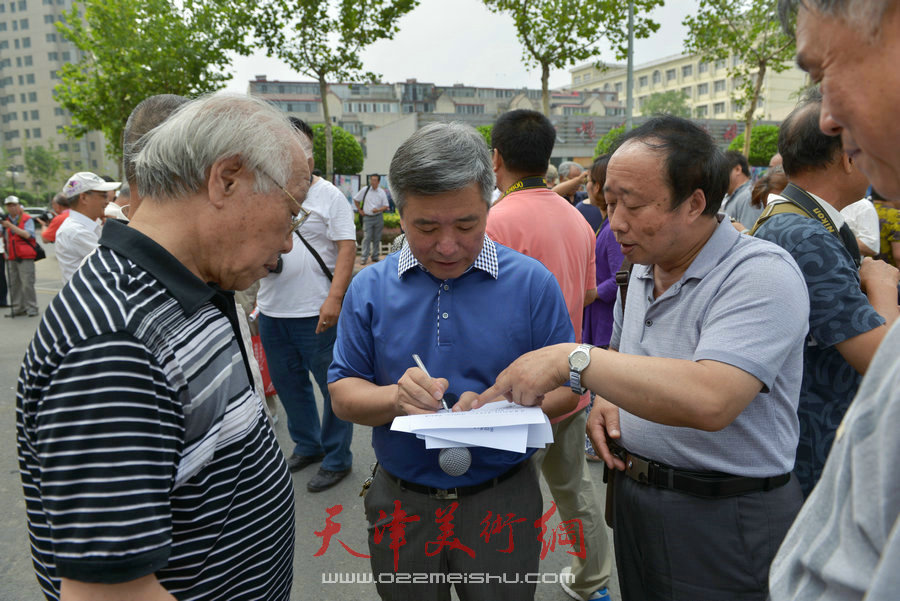 第四届“天穆杯”书画摄影展在北辰区天穆东苑举行，图为刘玉森（中）在现场。