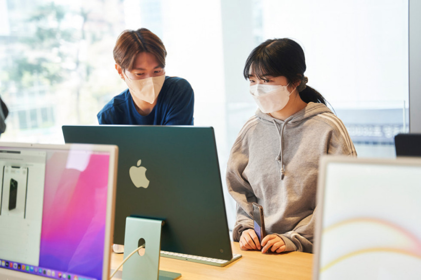 一名团队成员在 Apple 明洞店开业时协助一位顾客。